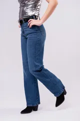 Jean de corte wide leg y tiro alto en color azul profundo, con diseño de cinco bolsillos y cierre frontal con botón y cremallera.
