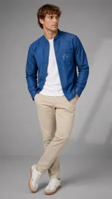 Camisa de jean azul con cuello mao y bolsillo frontal. Confeccionada en tejido de denim, presenta un diseño de manga larga con botones frontales.