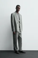 Pantalón de corte straight relaxed fit confeccionado en tejido de lino. Presenta cintura con pliegues frontales, cierre frontal con cremallera y botón, bolsillos laterales y bolsillos traseros con solapa.