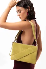 Cartera tipo sobre de cuero gamuza color negro, con diseño versátil que permite cuatro formas de uso: como sobre, colgado a la muñeca, al hombro o como bandolera. Incluye correa larga extraíble y correa corta para la muñeca.