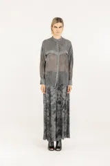 Camisa boxy oversize de viscosa y seda en color gris, con detalles de satén de viscosa y doble canesú en el frente y la espalda, teñida en frío. Tiene cuello mao, cierre frontal con botones, hombros caídos y mangas largas con puño, confeccionada en tejido liviano semitransparente.