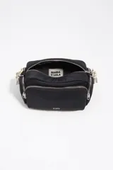Bolso bandolera mediano de nylon negro con estructura blanda, detalles en piel, asa de hombro combinada de piel y cordón decorativo blanco y negro, cierre de cremallera y logo metálico de la marca.