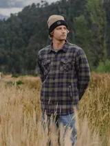 Camisa overshirt de franela con interior de chiporro, diseño a cuadros en tonos azul y verde, con cierre frontal de botones, bolsillos laterales y bolsillos frontales con solapa.
