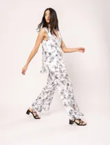 Pantalón de lino estampado con flores azules, de tiro alto y corte palazzo, con elástico en la pretina trasera, cierre delantero y broche interno. Tiene bolsillos laterales, dobladillo invisible y tajos a los costados.