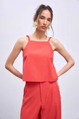 Blusa blanca sin mangas con tirantes finos y escote cuadrado.