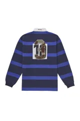 Camisa de rugby Supreme de manga larga con diseño de rayas horizontales en tonos azul marino y azul eléctrico. Presenta cuello polo blanco, cierre frontal con botones ocultos y apliques bordados con el nombre de la marca y el número 3 en el pecho.