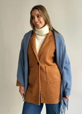 Ruana de tejido suave en color azul, con diseño de flecos en los extremos. Presenta una textura cálida y versátil para complementar diversos atuendos.