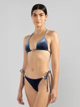 Bombacha de bikini azul de terciopelo con textura a rayas finas, corte triángulo clásico, tiras laterales ajustables y detalle de charm floral Polonio.