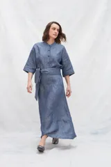 Falda midi azul de lino con bolsillos laterales, volante en el ruedo y tira en la cintura para anudar en la delantera.