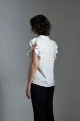 Blusa color crudo de tela satinada con escote en V y mangas cortas con volados.