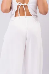 Pantalón palazzo negro de corte wide leg, confeccionado en tela ligera con caída y cintura elastizada de tiro medio-alto.