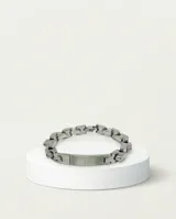 Pulsera de acero con eslabones gruesos y placa central rígida con detalle de circonia.
