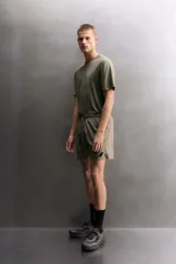 Short deportivo de entrenamiento color marrón, confeccionado en tejido técnico ligero y elástico. Cuenta con cintura elástica ajustable con cordón, bolsillos frontales, bolsillo trasero con cierre y aberturas laterales en el bajo. Incluye detalle de logo estampado en la pernera.
