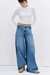 Jean de corte wide leg en color azul medio, con diseño de tiro alto y cierre frontal con botón y cremallera.