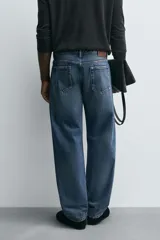 Jeans de corte recto en tono azul clásico con efecto lavado, tiro medio y diseño de cinco bolsillos con cierre frontal de botones.