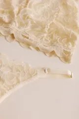 Soutien tipo bralette negro de encaje con diseño floral, espalda estilo nadador y elástico en el bajo busto para sujeción.