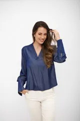 Blusa de tela tipo denim en color azul noche, con escote en V y mangas largas con puños anchos abotonados.