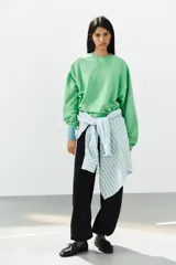 Sudadera de algodón color verde brillante con efecto lavado, cuello redondo con detalle de costura triangular, manga larga y acabados en rib.