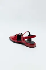 Sandalias chatitas Daniel Cassin color negro con textura símil reptil, punta cuadrada, taco bajo y doble tira delgada con hebilla metálica.