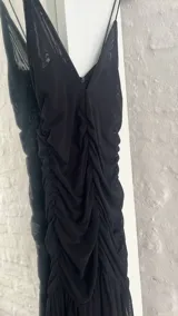 Vestido corto negro de microtul con breteles finos y escote en V.