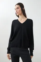 Sweater verde de tejido de punto, con escote en V y mangas largas.