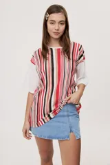 Remera oversize de manga corta con diseño de rayas verticales en tonos rojos, negros, blancos y tostados, y mangas blancas lisas.