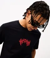 Remera negra de algodón con cuello redondo y mangas cortas, de corte comfort. Presenta una gran estampa en la espalda con una ilustración de Batman y tipografía en tonos rojos y blancos.