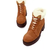 Botín acordonado de gamuza color marrón con cuello de piel sintética color crema. Tiene suela de goma color marrón oscuro con plataforma y taco cuadrado.