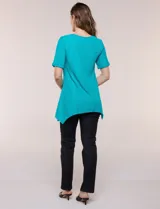 Blusa blanca de tejido de punto liviano con textura labrada en franjas verticales y caladas, de silueta evasé, con escote redondo, manga corta y ruedo asimétrico en picos.