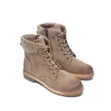 Borcego color taupe de símil gamuza, con caña media y cuello tejido con textura trenzada. Presenta cordones al tono con ojales metálicos, cierre interno, lengüeta acolchonada, punta redondeada, taco bajo símil madera y suela de goma antideslizante.