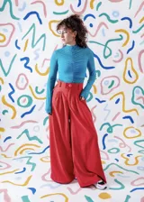 Pantalón sastrero de corte ancho y tiro alto, color celeste, con pinzas delanteras y cierre frontal con botón de acrílico.