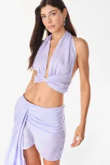 Top color blanco de lino italiano, con diseño de escote halter pronunciado, espalda descubierta y nudo frontal.