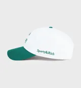 Gorro de béisbol blanco con visera verde y logo bordado en verde con la frase "Health is Wealth!".