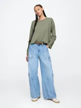 Remera de manga larga color salmón, con cuello redondo y corte holgado.