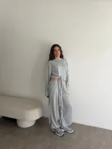 Conjunto de dos piezas de viscosa y poliéster color gris melange, compuesto por un buzo de manga larga y un pantalón largo de corte recto con lazo ajustable en la cintura.