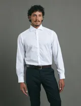 Camisa de vestir de manga larga, confeccionada en popelina fina de algodón, con cuello clásico y cierre frontal de botones.