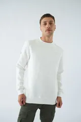 Buzo blanco de algodón con cuello redondo, mangas largas y logo y arte en relieve en el frente.