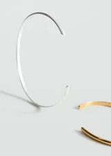 Pack de dos pulseras rígidas abiertas tipo brazalete de acero inoxidable, una en tono dorado y otra en tono plateado, con diseño minimalista y elegante.