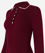 Vestido corto de punto color borgoña, con cuello polo blanco abotonado y mangas largas.