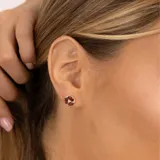 Aros de plata 925 con tres piedras granate y un topacio blanco central.