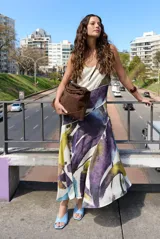 Vestido largo sin mangas de corte evasé con estampado abstracto en tonos bordó, beige y rosado, escote en V y tirantes finos.