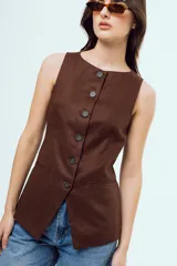 Top tipo chaleco color bordó sin mangas, con cuello redondo y cierre frontal de botones oscuros. Presenta bolsillos ojal simulados en la parte inferior.