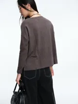 Buzo tejido de punto con diseño de rayas horizontales, cuello redondo y calce holgado con tajos laterales.