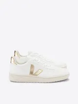 Zapatillas Veja V-10 de cuero blanco con logo lateral en dorado y refuerzo trasero dorado.