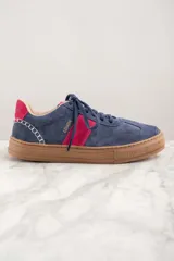 Zapatillas de gamuza azul con detalles en fucsia y suela marrón.