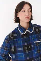 Camisa de corte holgado en color bordó con estampado de cuadros y monograma. Presenta cuello redondo con borde de puntilla, bolsillo frontal con detalle de puntilla, cierre frontal con botones y puños con terminación en puntilla.