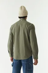 Camisa rústica lisa de manga larga color verde militar, con cuello clásico y dos bolsillos frontales con solapa.