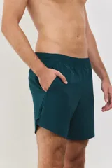 Short deportivo de hombre, confeccionado en tejido liviano y respirable con spandex para mayor movilidad. Presenta cintura elástica de 4 cm, bolsillos laterales y logo de la marca estampado en el ruedo. Diseño de largo medio con aberturas laterales.