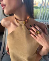 Top marrón de cuero con cuello halter y espalda descubierta.