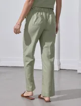 Pantalón de corte recto confeccionado en mezcla de lino, color verde claro. Presenta una pretina ancha con lazo de ajuste frontal y bolsillos laterales verticales.
